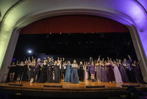 Purple side and gold side await the announcement of the winner of 2025 College Night on the Palmer Hall auditorium stage.